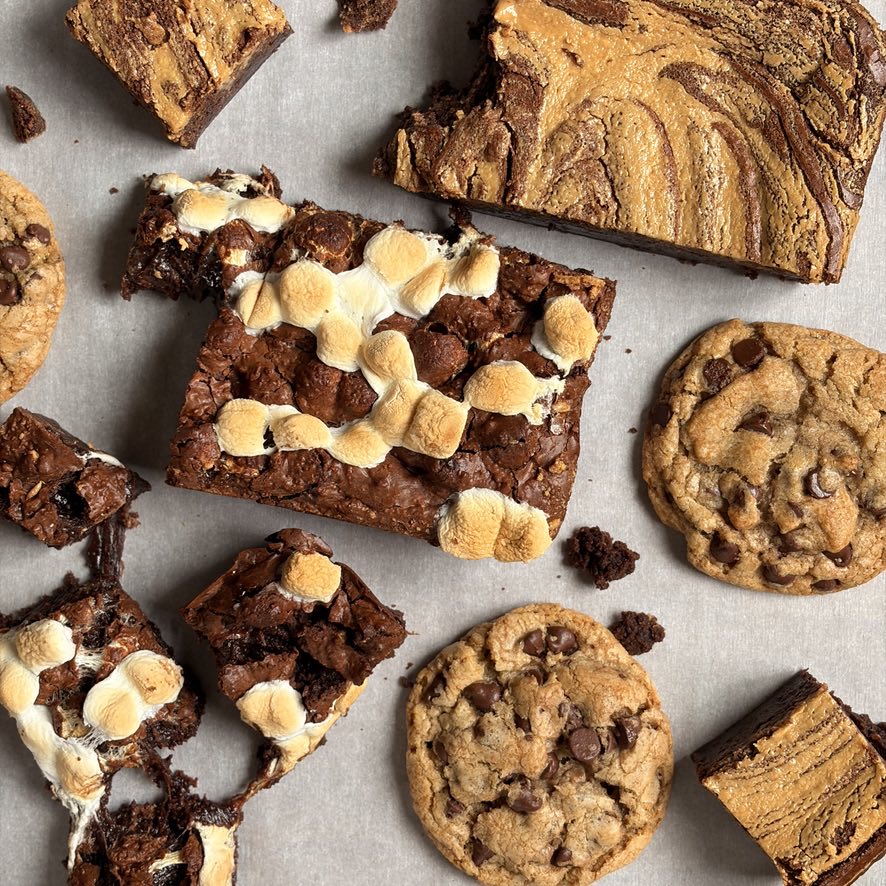 Cookies, s'mores brownies, and peanut butter swirl sweet bread arranged on parchment